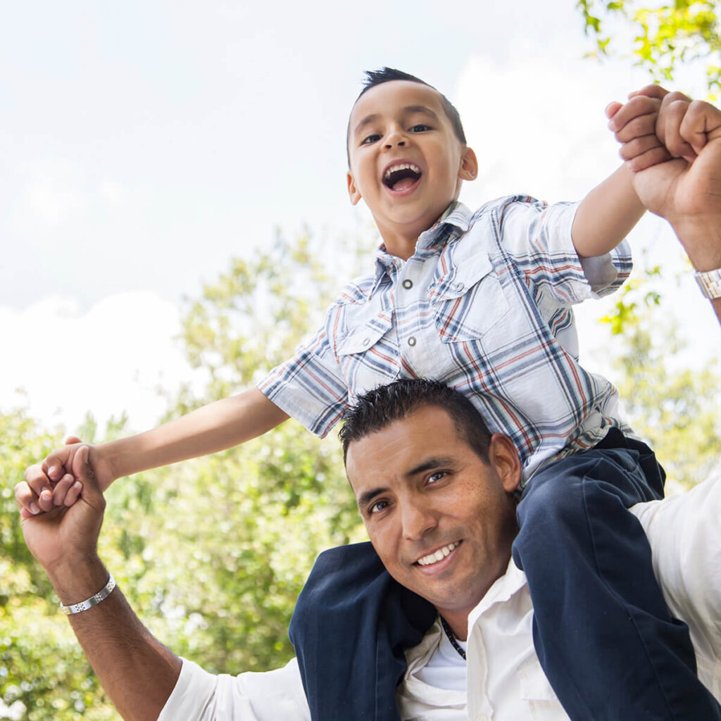 Hispanic Father with his son on his shoulders